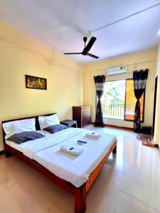 ein Schlafzimmer mit einem großen Bett und einem Deckenventilator in der Unterkunft STARFISH Resort in Nagaon
