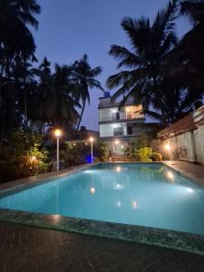 ein großes Schwimmbad vor einem Gebäude bei Nacht in der Unterkunft STARFISH Resort in Nagaon + 6 Fotos