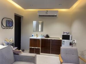 ein Wohnzimmer mit einer Küche mit einer Spüle und einer Mikrowelle in der Unterkunft Red Mountain Suites in Al-'Ula + 13 Fotos