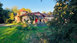 an old house in a field with a grass yard at Métairie de Moutiques in Cazaubon
