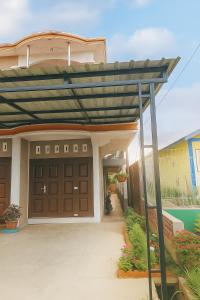 une pergola au-dessus d'un garage dans une maison dans l'établissement Penginapan The Guardians, à Silangit International Airport