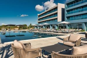 a swimming pool with chairs and a building at Delta Hotels by Marriott Azores in Ponta Delgada