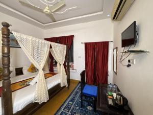 ジャイサルメールにあるHotel Aryan Villaのベッドルーム(天蓋付きベッド、テレビ付)