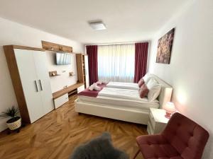 ein Schlafzimmer mit einem Bett und einem Stuhl darin in der Unterkunft Luxury Apartment in Făgăraş