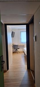 a hallway with a room with a bed and a window at N'Atura Hôtel in Aire-sur-lʼAdour