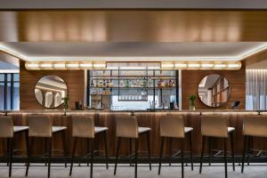 a bar in a hotel with chairs and mirrors at AC Hotel by Marriott Old Montreal in Montréal