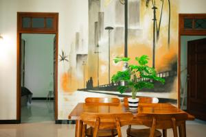 a dining room with a wooden table with a potted plant at Ijen Vibe's Inn in Banyuwangi