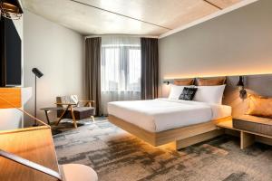 a hotel room with a bed and a couch at Moxy Hamburg - Finkenwerder in Hamburg