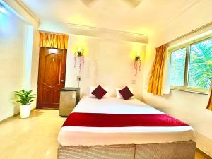 a bedroom with a large bed with a red blanket at Hotel El - Paso in Arambol