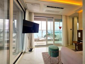 a living room with a couch and a tv in a room at Raviens Maison de Hotel in Busan
