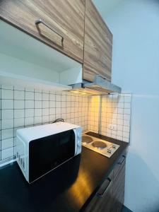 a microwave sitting on a counter in a kitchen at Arin Townhome @Bangtao in Ban Thalat Choeng Thale