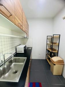 a kitchen with a sink and a counter top at Arin Townhome @Bangtao in Ban Thalat Choeng Thale