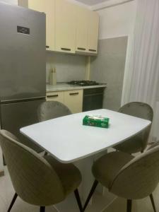 a kitchen with a white table and chairs and a refrigerator at Cristian's Home in Drobeta-Turnu Severin