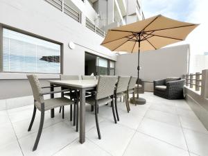 un patio avec une table, des chaises et un parasol dans l'établissement Coastal Hospitality - De Valle 24, à Mossel Bay
