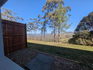 a wooden fence with a view of a field at Maleny-Montville Cottages #4 - 2 bed with ocean view in Maleny