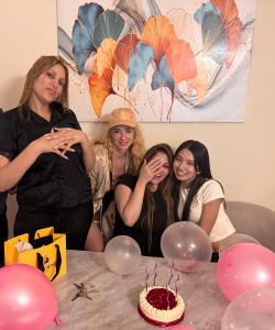 a group of women standing around a table with a cake at Shams Wa Bahar Vacation Homes Rental in Dubai