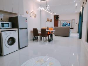 a kitchen with a washing machine and a table with chairs at Danga Bay Seaview Johor Bahru by One 9 Place in Johor Bahru