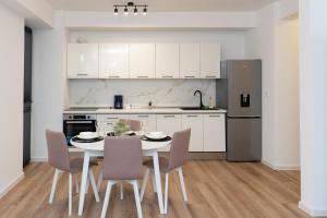 a kitchen with a table and chairs and a refrigerator at Milan Luxury Apartaments XIII#Tudor in Corunca +8 photos