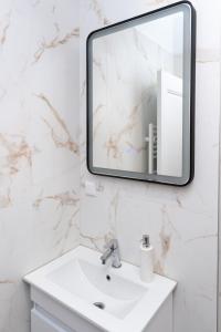 コルンカにあるMilan Luxury Apartaments XIII#Tudorの洗面台と鏡のある白いバスルーム +9枚の写真