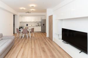 コルンカにあるMilan Luxury Apartaments XIII#Tudorのソファとテーブルと椅子のあるリビングルーム