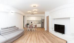 コルンカにあるMilan Luxury Apartaments XIII#Tudorの白いソファとキッチンのあるリビングルーム