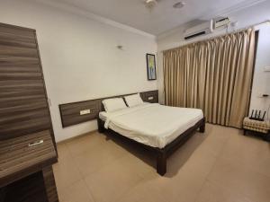 a bedroom with a bed and a dresser in it at Marvella Stays in Anjuna
