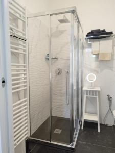 a glass shower in a bathroom with a stool at Jewel on Lake Garda in Garda with Lake view in Garda