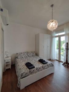 a bedroom with a bed and a chandelier at Jewel on Lake Garda in Garda with Lake view in Garda +32 photos