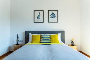 1 dormitorio con 1 cama con almohadas amarillas y azules en HARLEY STYLE APARTAMENT, en Muszyna