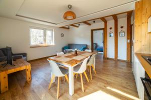 Un comedor con mesa y sillas de madera. en HARLEY STYLE APARTAMENT, en Muszyna