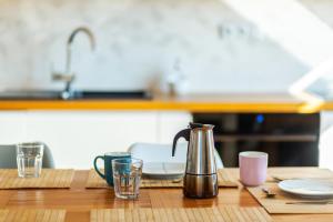 una mesa de madera con tetera y vasos. en HARLEY STYLE APARTAMENT, en Muszyna