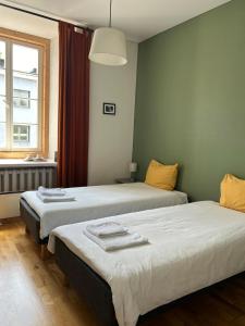 two beds sitting in a room with a window at Bookinn B&B Vilnius' Old Town in Vilnius