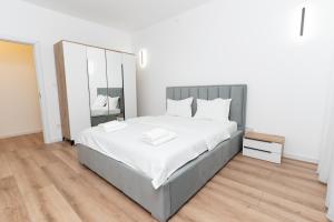 コルンカにあるMilan Luxury Apartaments XV#Tudor#Targu Muresの大きなベッドと鏡のある寝室