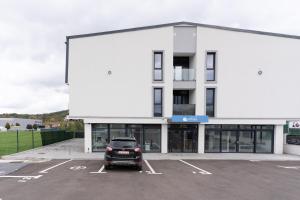 コルンカにあるMilan Luxury Apartaments XV#Tudor#Targu Muresの建物の前の駐車場に駐車された車