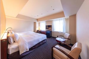 a hotel room with a bed and a desk at Hotel Keihan Sapporo in Sapporo +77 photos