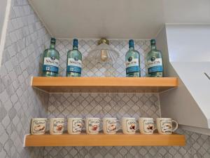 ein Haufen Weinflaschen und Tassen auf Regalen in der Unterkunft 2BR Penthouse SMDC Wind Residences Tagaytay in Kaybagal
