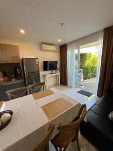 Ka RornにあるCozy Garden Apartment Butterfly Karon Beachのキッチンとテーブルとソファのあるリビングルーム