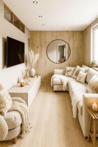 a living room with a couch and a mirror at Ma Montagne Chic 3 in La Bresse