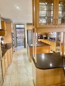 a large kitchen with wooden cabinets and a counter top at Gugu's Holiday Home in Durban