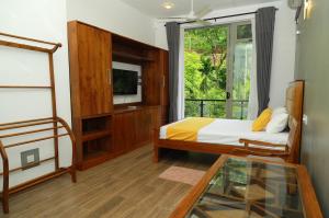 a bedroom with a bed and a tv and a window at River View Stay in Latpandura
