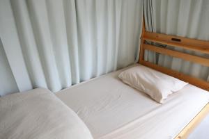 a small bed with a white pillow on it at 2-times,Dormitory Hotel - Vacation STAY 55232v in Itoshima +4 photos