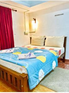 a bedroom with a large bed with a blue blanket at Pearl House Residency in Jāmb