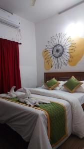 two beds in a room with a flower on the wall at Pearl House Residency in Jāmb