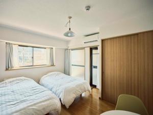 a bedroom with two beds and a window at vetta kumamoto suizenji2 204 in Kumamoto