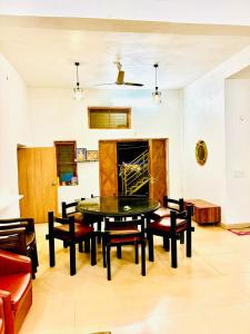 a living room with a table and chairs and a fireplace at Oceanwood Beachfarm Alibaug in Nagaon