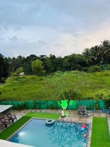 a swimming pool with a tree in the middle of a yard at Oceanwood Beachfarm Alibaug in Nagaon
