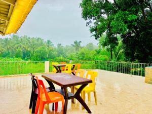 a wooden table and chairs on a patio at Oceanwood Beachfarm Alibaug in Nagaon