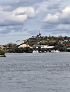a town on top of a hill next to the water at Danubius view apartment in Tulcea