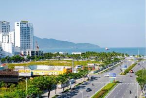 a street in a city with buildings and the ocean at GOLDEN SUN DANANG Hotel in Da Nang