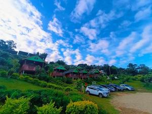 a group of cars parked in front of a resort at โฮมสเตย์ภูชี้ฟ้า in Ban Huai Khu